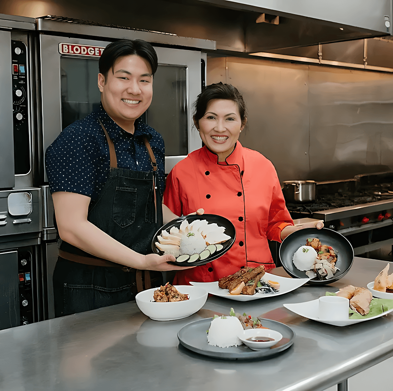 Khue Pham, lead chef at Quang Restaurant, smiling and posing with her son, Eric Pham, in a professional kitchen.